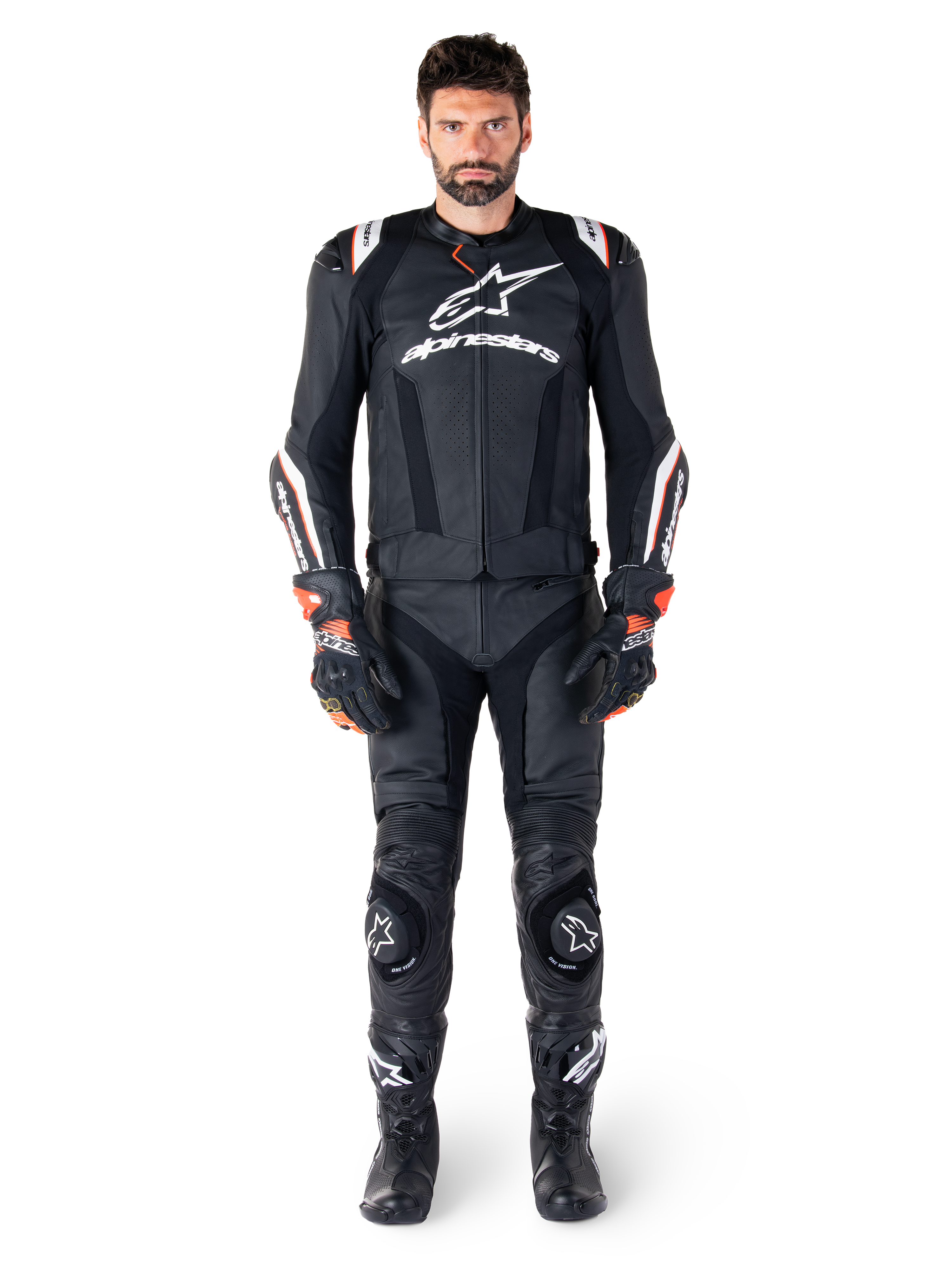 Männlicher Motorradfahrer in der Alpinestars Missile V3 Ignition Lederjacke in Schwarz, kombiniert mit passender Lederhose, Handschuhen und Stiefeln, mit weißem Alpinestars-Branding und roten Akzenten, entwickelt für professionelle Rennsportleistung.