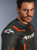 Alpinestars GP Force V2 Airflow Lederjacke, Schwarz Rot Fluo, getragen von einem männlichen Model, mit perforiertem Leder, GP Lite Evo DFS Schulterschleifern und Alpinestars-Logo-Branding, Sport-Motorrad-Schutzausrüstung