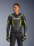 Blouson en cuir Alpinestars GP Force V2 Air, noir et jaune fluo, blouson de moto en cuir perforé avec protections et accents néon, porté avec des gants de course assortis et un pantalon noir, coupe sport athlétique avec marquage distinctif