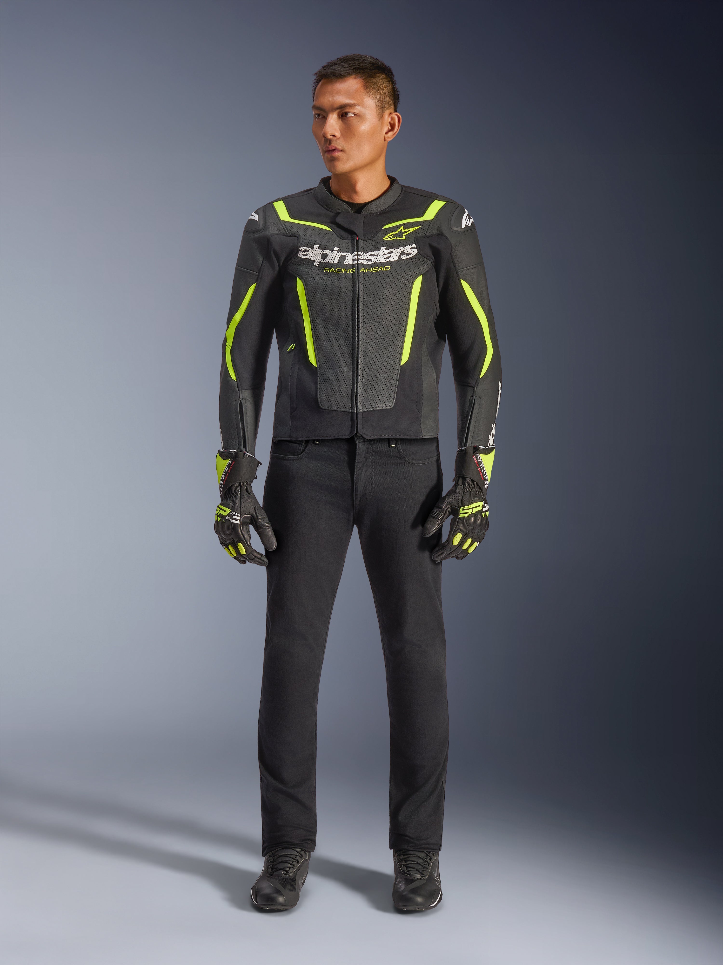 Alpinestars GP Force V2 Air Leather Jacket, noir et jaune fluo, blouson de sport en cuir perforé avec des accents jaunes vifs et logo Alpinestars, porté avec un pantalon noir et des gants de moto assortis