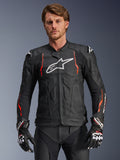 Veste en cuir Alpinestars Dusk Airflow, noire avec des accents rouge fluo et blancs, veste de moto de course en cuir, dotée de perforations étendues pour la ventilation, d'un logo blanc sur la poitrine et de sliders d'épaules externes, portée par un mannequin avec des gants de course assortis.