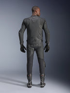 Mannelijk model van achteren getoond, draagt de Alpinestars Dusk Airflow leren jas in het zwart, gecombineerd met bijpassende zwarte leren racebroek, handschoenen en laarzen, voorzien van uitgebreide perforaties voor ventilatie en het Alpinestars-logo op de onderrug.