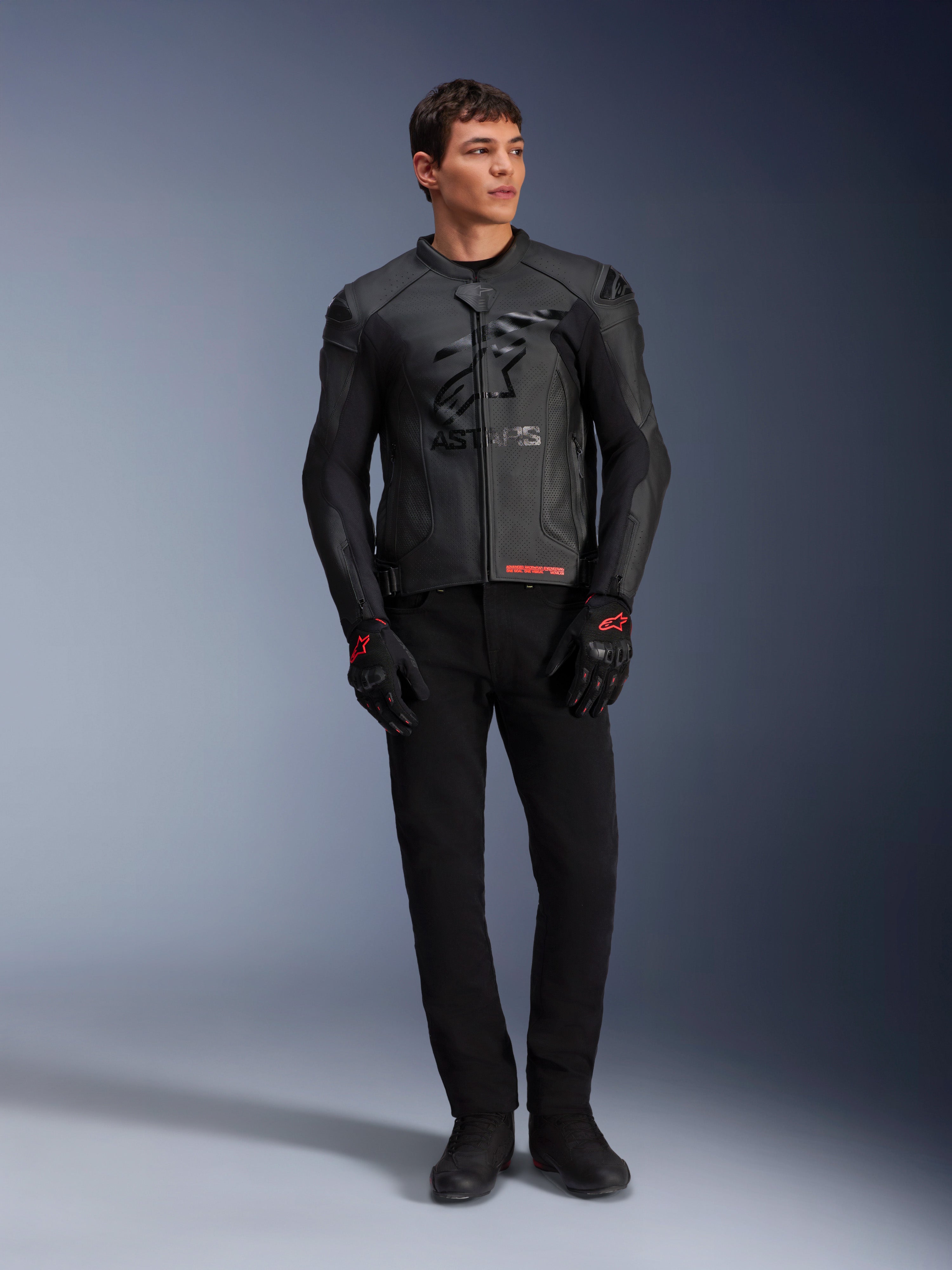 Alpinestars GP Plus R V4 Airflow Lederjacke, Schwarz, getragen von einem männlichen Model mit passenden schwarzen Handschuhen und Hosen, mit perforierten Lederbahnen, großem tonalen Stern-Logo auf der Brust und schlanker sportlicher Passform