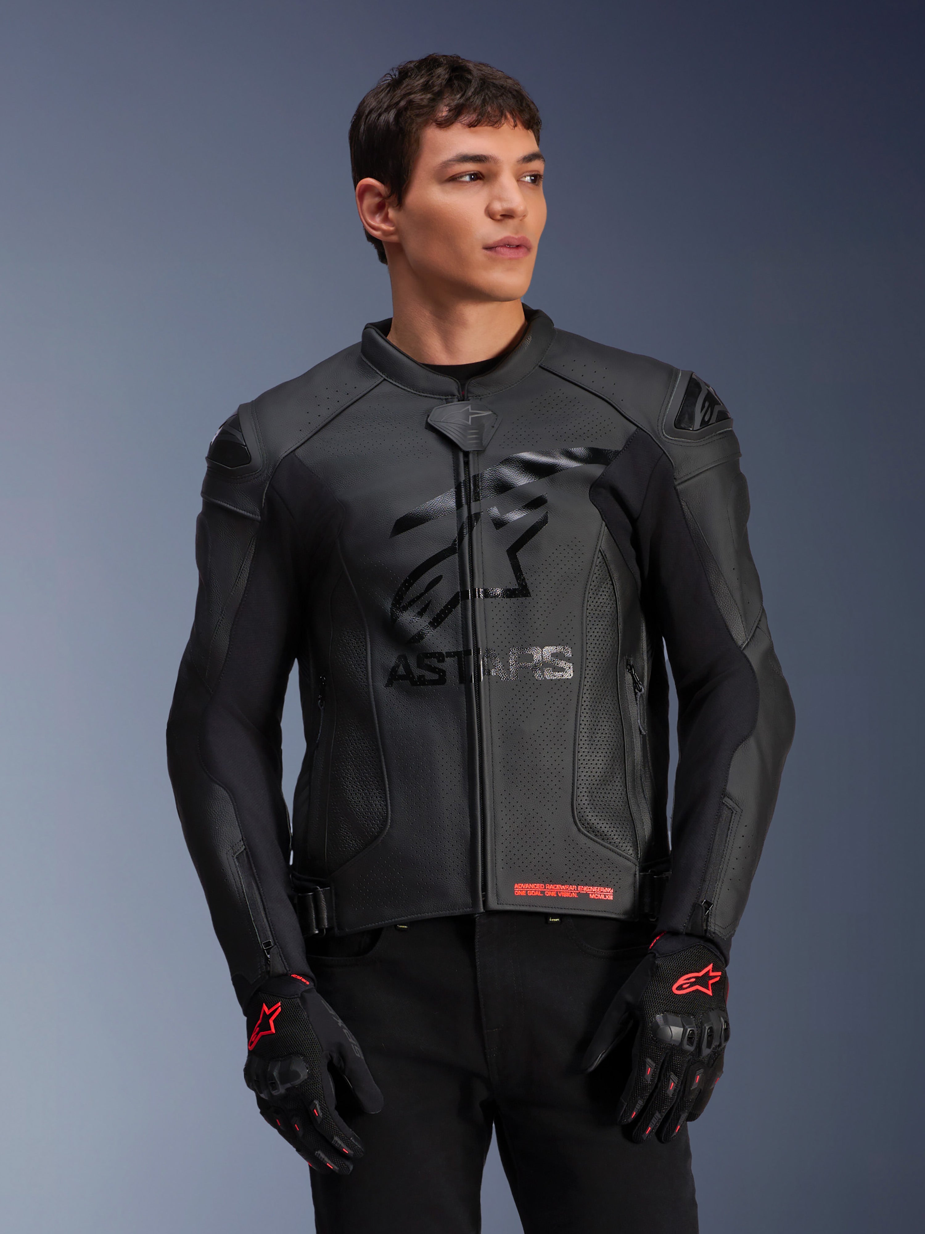 Alpinestars GP Plus R V4 Airflow Lederjacke, Schwarz, Motorrad-Rennjacke mit perforierter Lederkonstruktion, markantem ASTARS-Branding auf der Brust und DFS-Schulterschutz, getragen mit schwarz-roten Handschuhen
