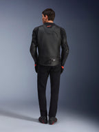 Alpinestars GP Plus R V4 Airflow Lederjacke, Schwarz, Rückansicht eines Fahrers in kompletter Ausrüstung, mit perforiertem Leder für Belüftung und roten Logo-Akzenten, schlankes Sport-Fit-Design, kombiniert mit schwarzer Hose und Motorradstiefeln