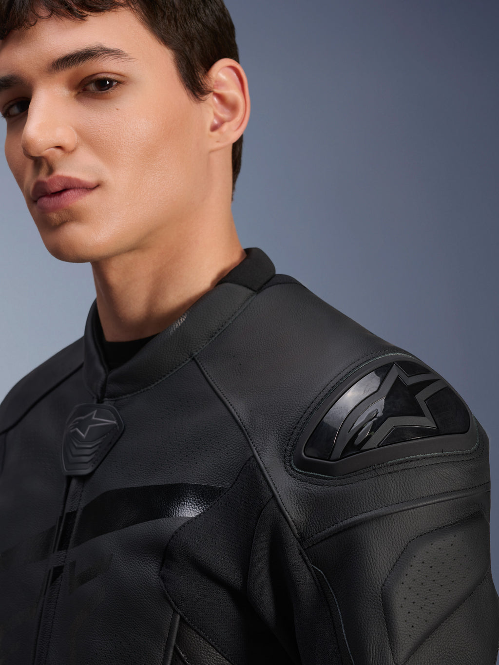 Alpinestars GP Plus R V4 Airflow Lederjacke, Schwarz, Nahaufnahme an einem Model mit Dual-Density DFS Schulterprotektor und perforiertem Leder, professionelle Sport-Motorradausrüstung