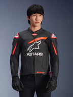 Alpinestars GP Plus R V4 Airflow Lederjacke, Schwarz mit Red Fluo und weißen Akzenten, von einem Modell getragen, perforierte Lederkonstruktion, großes weißes ASTARS-Logo auf der Brust, integrierter Schulterschutz für Motorradrennen