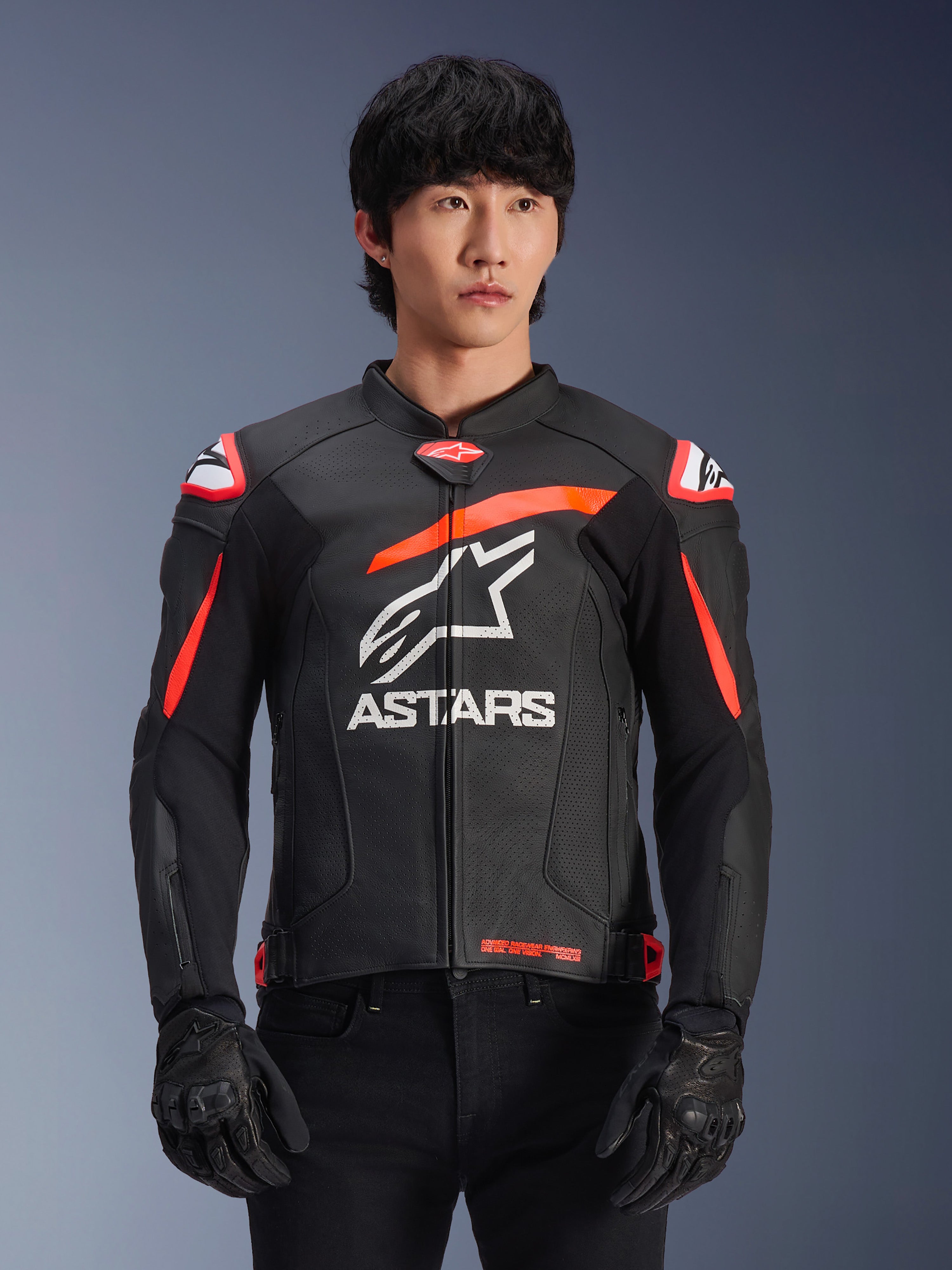 Alpinestars GP Plus R V4 Airflow Lederjacke, Schwarz mit Red Fluo und weißen Akzenten, von einem Modell getragen, perforierte Lederkonstruktion, großes weißes ASTARS-Logo auf der Brust, integrierter Schulterschutz für Motorradrennen