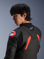 Alpinestars GP Plus R V4 Airflow Lederjacke, Schwarz mit Akzenten in Red Fluo und Weiß, Nahaufnahme von Rücken und Schulter an einem Modell, mit perforierten Lederzonen, Alpinestars-Logo und integriertem Schulterprotektor für Motorrad-Performance.