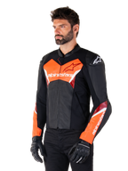 Alpinestars Faster V3 Lederjacke, Schwarz und Fluo-Rot, Premium-Sport-Motorradjacke mit weißen und roten Akzenten, Alpinestars-Branding auf Brust und Ärmeln, getragen mit schwarzen Motorradhandschuhen und Hosen.