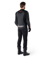 Alpinestars Faster V3 Lederjacke, Sport-Motorradjacke, Schwarz und Rot Fluo, Rückansicht getragen mit schwarzer Hose und schwarzen Stiefeln, mit „alpinestars RACING AHEAD“-Schriftzug am unteren Rücken und einem kleinen roten Stern-Logo, schlanke Lederkonstruktion in sportlicher Passform