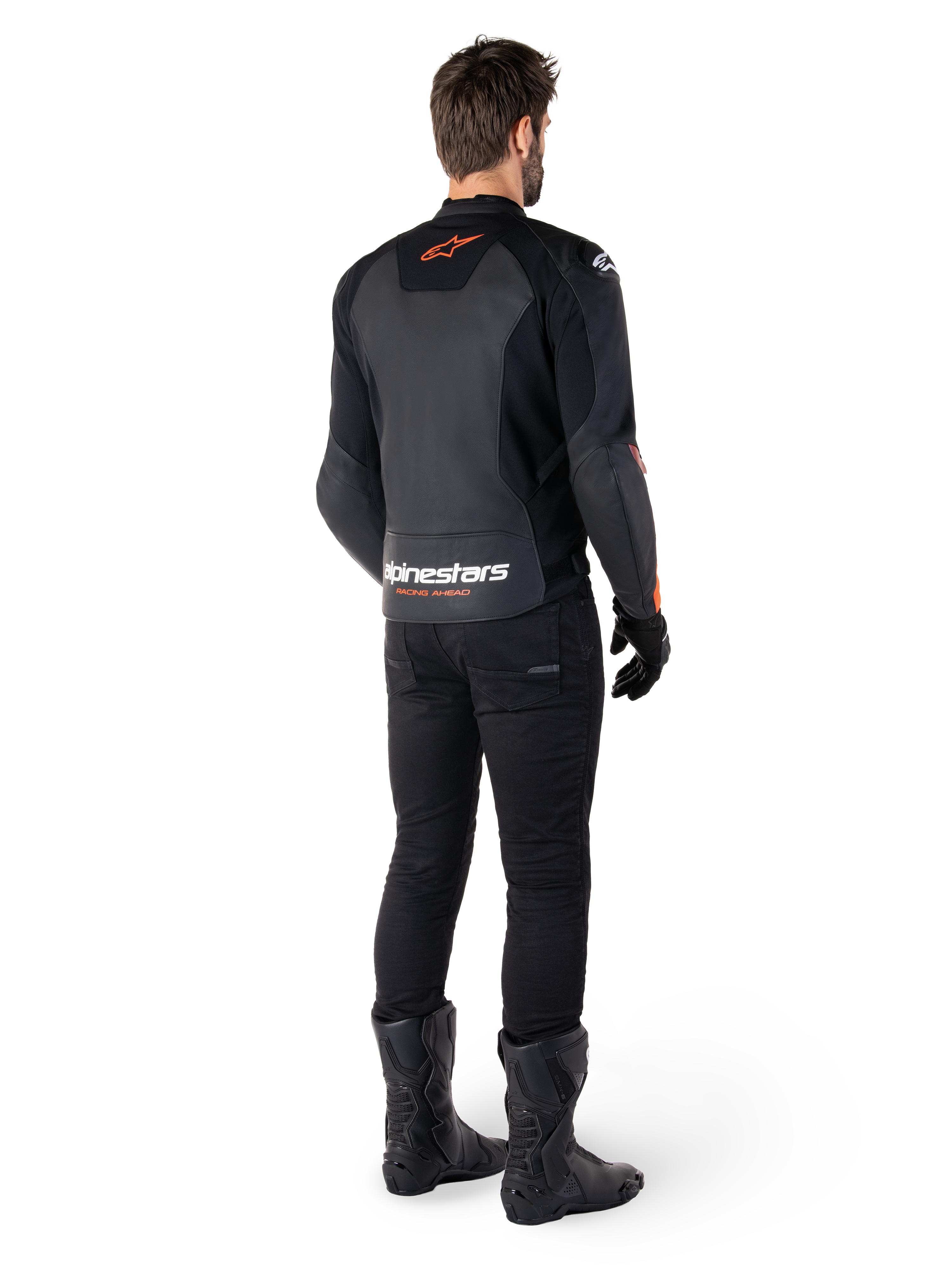Alpinestars Faster V3 Lederjacke, Sport-Motorradjacke, Schwarz und Rot Fluo, Rückansicht getragen mit schwarzer Hose und schwarzen Stiefeln, mit „alpinestars RACING AHEAD“-Schriftzug am unteren Rücken und einem kleinen roten Stern-Logo, schlanke Lederkonstruktion in sportlicher Passform