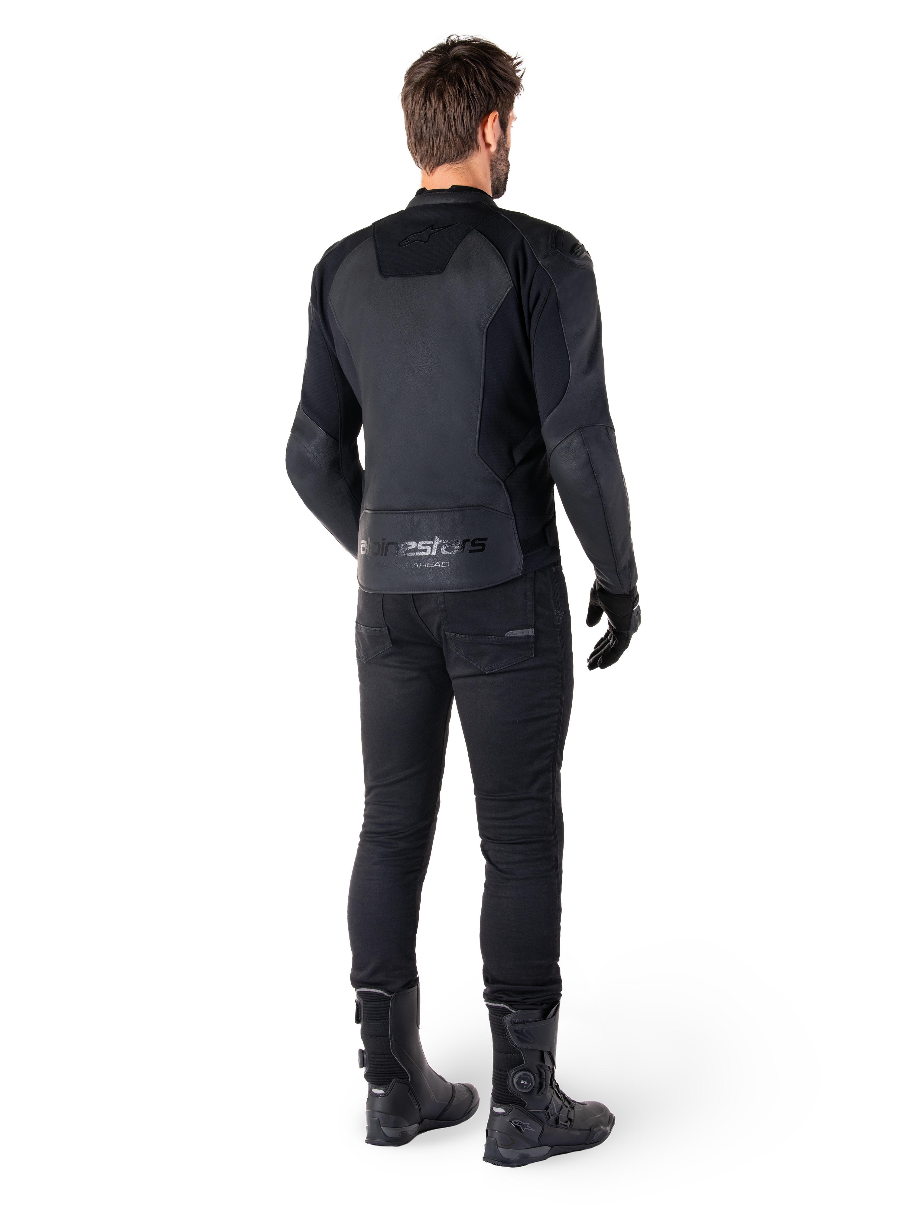 Alpinestars Faster V3 Lederjacke, Schwarz Schwarz, Rückansicht eines Fahrers, mit hochwertigen Lederpaneelen und geprägtem Alpinestars-Branding, kombiniert mit schwarzer Motorradhose und Stiefeln für einen kompletten Sport-Motorrad-Look.