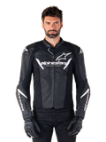 Alpinestars Faster V3 Lederjacke, schwarz-weiße Motorrad-Rennjacke, mit markanten weißen Logos und 'Racing Ahead'-Schriftzug auf der Brust, elegantes Lederdesign mit markanten Akzenten an den Ärmeln, getragen mit schwarzen Rennhandschuhen