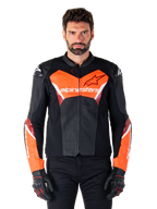 Blouson en cuir Alpinestars Faster V3 Airflow, blouson de moto de course, noir et rouge fluo, construction en cuir perforé avec des accents blancs et rouges, porté avec des gants noirs, équipement de performance pour la route