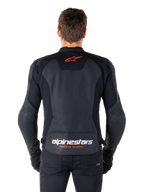 Veste en cuir Alpinestars Faster V3 Airflow, noire, vue arrière avec panneaux en cuir perforé pour la ventilation, logo étoile Alpinestars rouge et marquage blanc dans le bas du dos, portée avec un pantalon et des gants noirs.