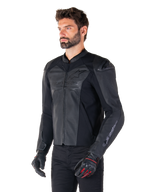 Mannequin portant la veste en cuir Alpinestars Faster V3 Airflow en noir, veste de moto de sport avec cuir perforé et panneaux extensibles, associée à un pantalon noir et des gants noirs avec des accents rouges, style épuré dérivé de la course.
