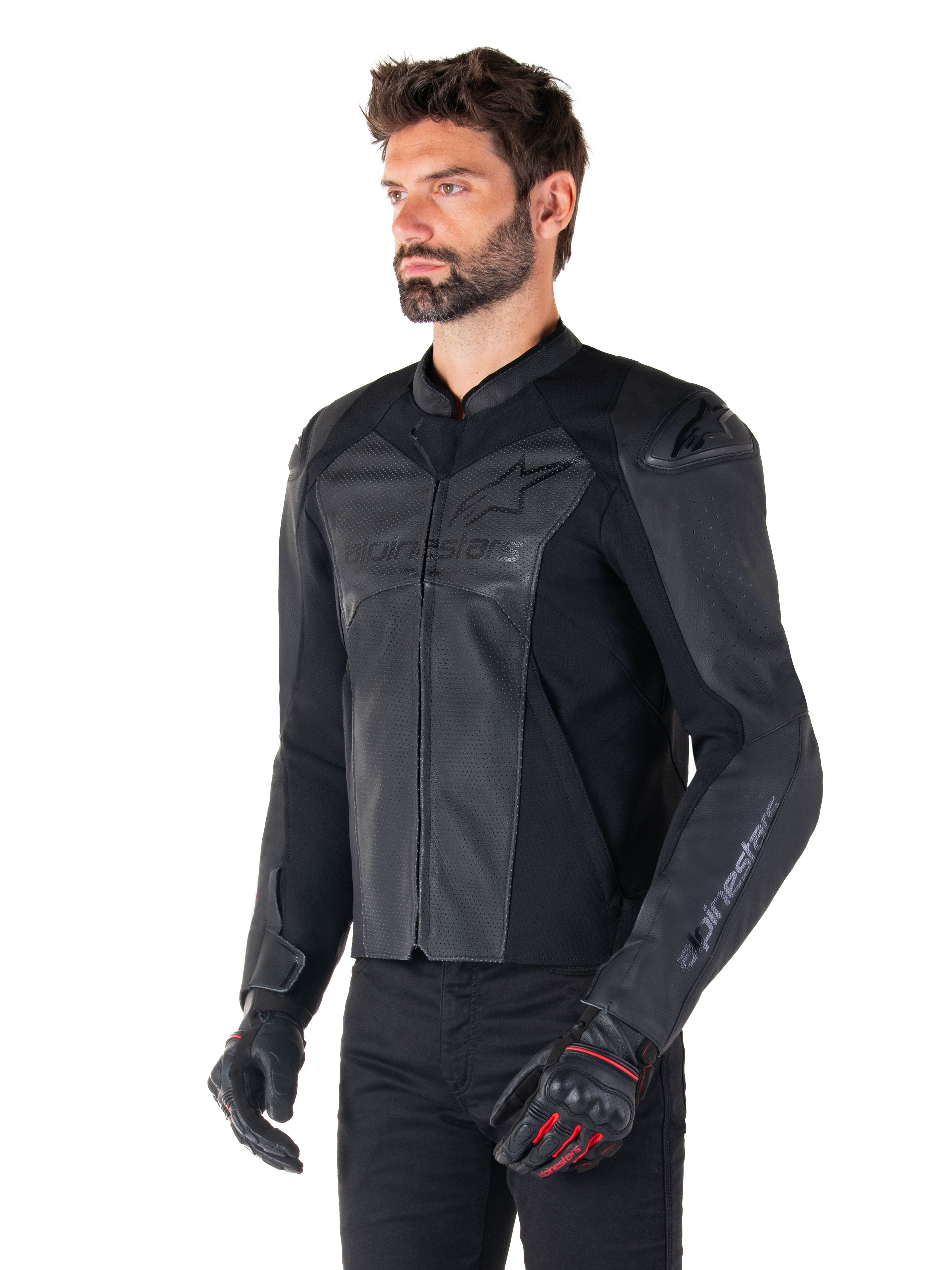 Mannequin portant la veste en cuir Alpinestars Faster V3 Airflow en noir, veste de moto de sport avec cuir perforé et panneaux extensibles, associée à un pantalon noir et des gants noirs avec des accents rouges, style épuré dérivé de la course.