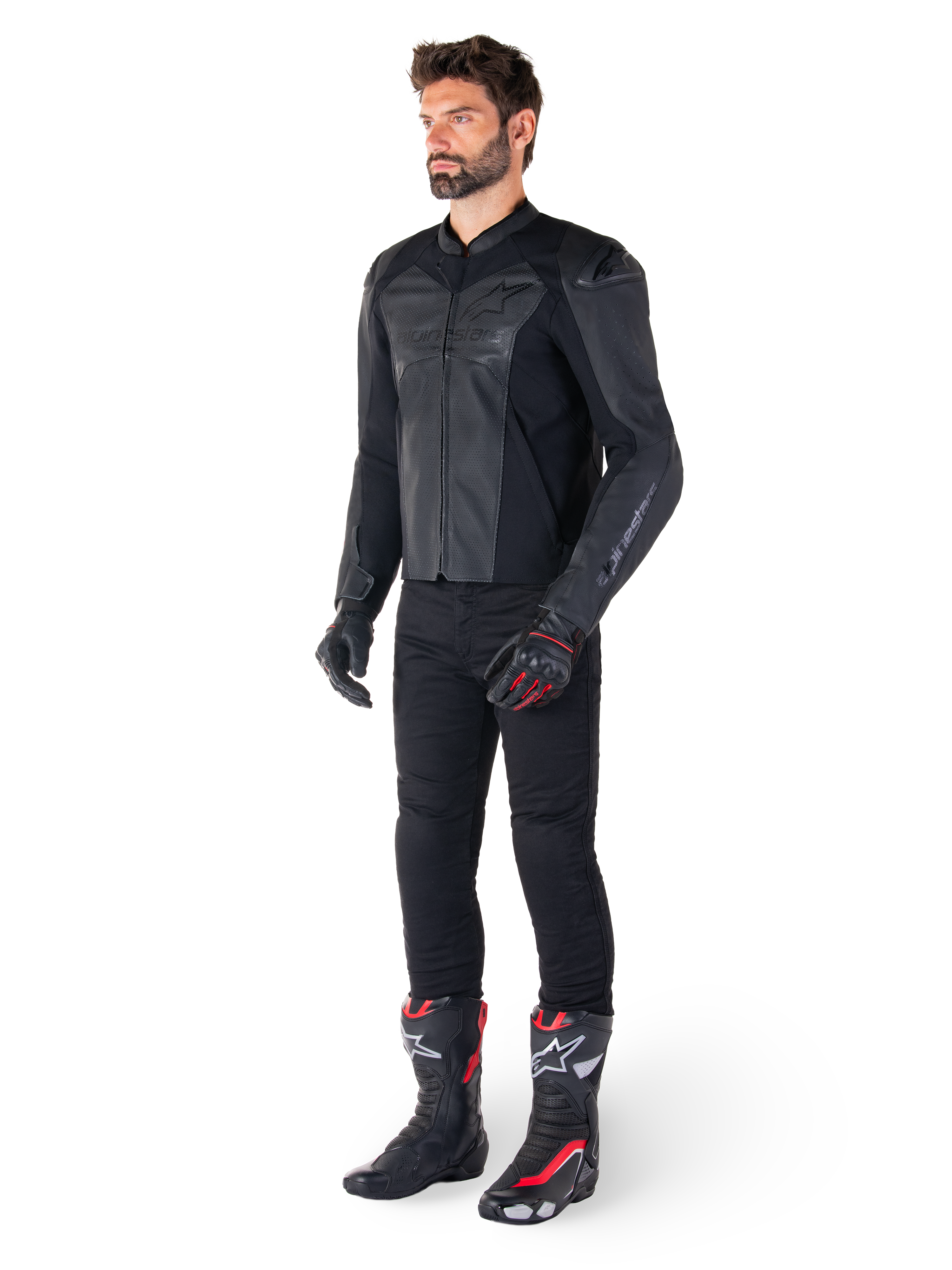 Homme portant la veste en cuir Alpinestars Faster V3 Airflow en Noir Noir, associée à un pantalon noir, des gants de moto noirs et rouges, et des bottes de course noires avec des accents rouges et blancs, équipement de conduite sportive complet