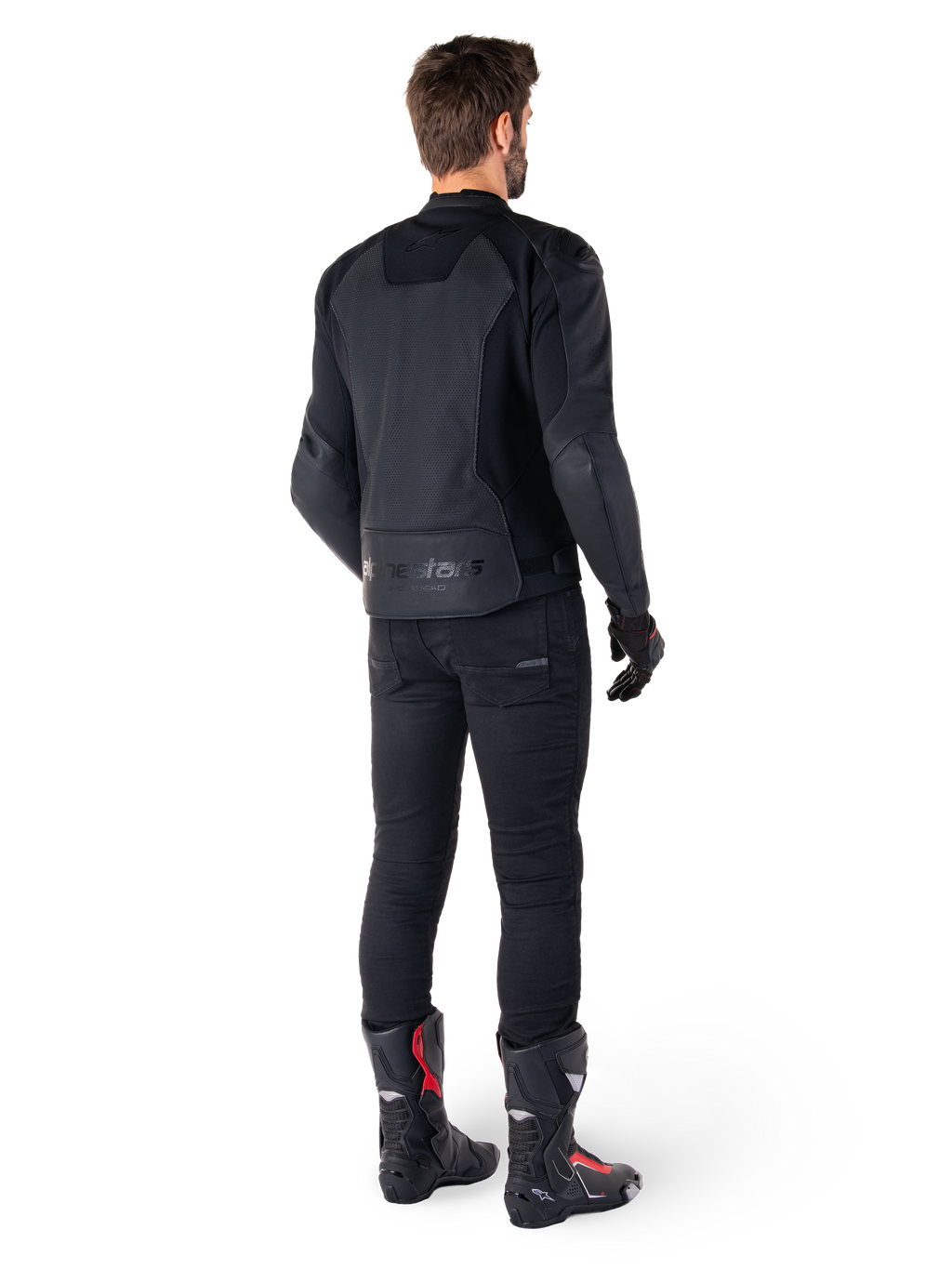 Veste en cuir Alpinestars Faster V3 Airflow, Noir, vue arrière d'un homme portant une veste de moto en cuir avec des panneaux perforés au dos et le marquage Alpinestars, assortie d'un pantalon de moto noir et de bottes noires et rouges.