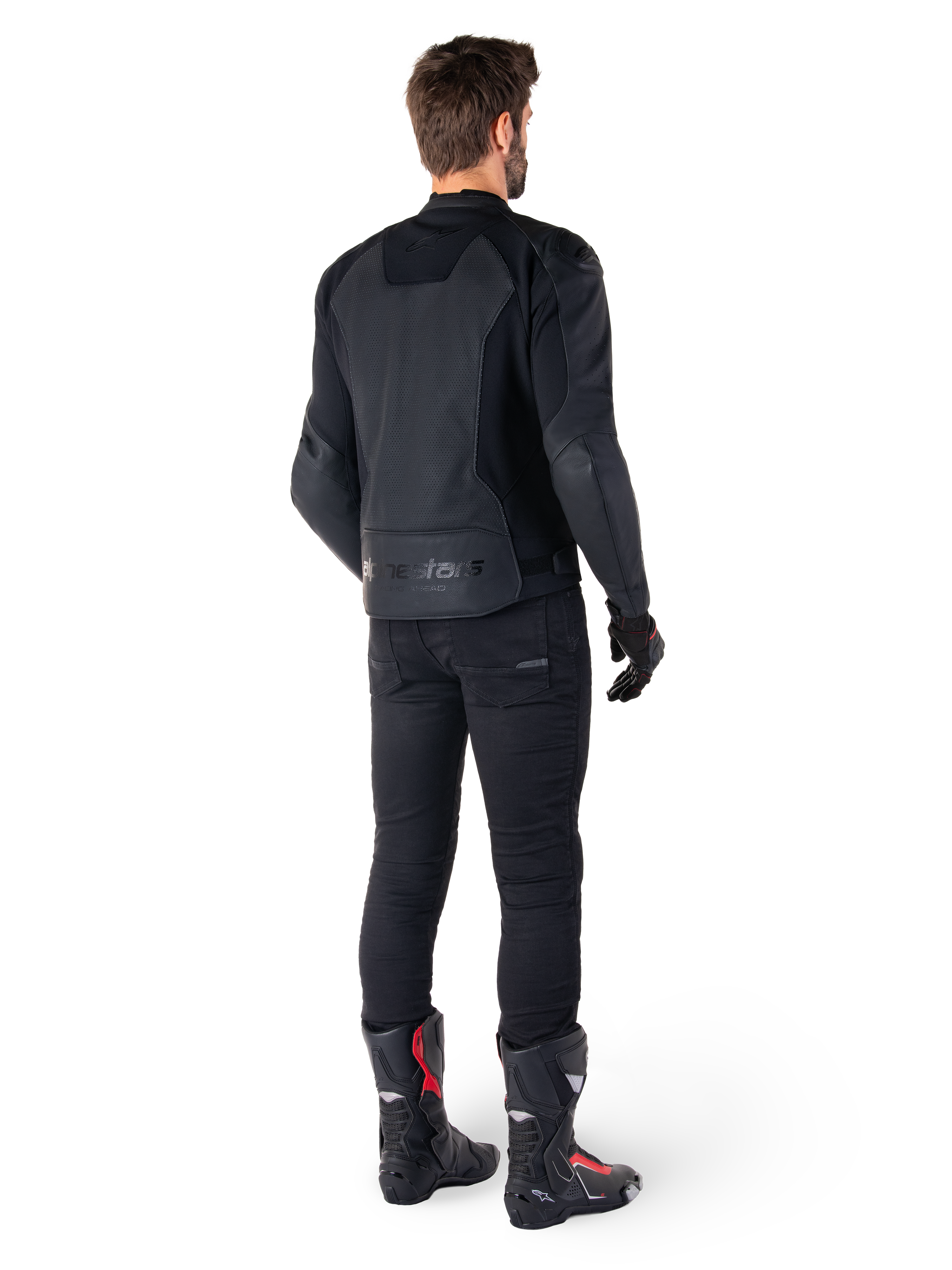 Veste en cuir Alpinestars Faster V3 Airflow, Noir, vue arrière d'un homme portant une veste de moto en cuir avec des panneaux perforés au dos et le marquage Alpinestars, assortie d'un pantalon de moto noir et de bottes noires et rouges.