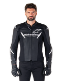 Veste en cuir Alpinestars Faster V3 Airflow, veste de moto noire avec accents blancs, panneaux en cuir perforé pour la ventilation, logo Alpinestars sur la poitrine, portée avec des gants noirs, construction en cuir d'inspiration sportive