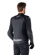 Veste en cuir Alpinestars Faster V3 Airflow, noir et blanc, vue arrière sur un mannequin, dotée d'un dos en cuir perforé pour la ventilation, logos Astars blancs sur le haut du dos et le bas de la taille avec le texte « Racing Ahead », design sportif avec empiècements extensibles pour la moto.