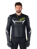 Veste en cuir Alpinestars Faster V3 Airflow, noir, blanc et jaune fluo, portée par un mannequin homme avec des gants noirs assortis, dotée de panneaux en cuir perforé pour la ventilation et d'un logo Alpinestars distinctif sur la poitrine, équipement de moto sportive