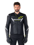 Veste en cuir Alpinestars Faster V3 Airflow, noir, blanc et jaune fluo, portée par un mannequin homme avec des gants noirs assortis, dotée de panneaux en cuir perforé pour la ventilation et d'un logo Alpinestars distinctif sur la poitrine, équipement de moto sportive