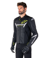 Veste en cuir Alpinestars Faster V3 Airflow, veste de moto sportive, noir, blanc et jaune fluo, portée par un homme, cuir perforé pour une ventilation optimale, logos Alpinestars sur la poitrine et les bras, avec gants noirs