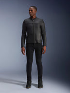 Modèle masculin portant la veste en cuir Alpinestars Blacktrack, cuir de bovin noir de première qualité, design de motard minimaliste moderne avec une coupe sur mesure, associé à un pantalon de conduite et des bottes noirs, style urbain contemporain