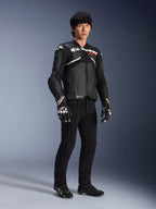 Alpinestars Atem V5 Leren Jas, motorracejas, zwart en wit, gedragen met een zwarte broek en bijpassende handschoenen, met witte Alpinestars-branding op de borst en beschermende schouderprotectie.