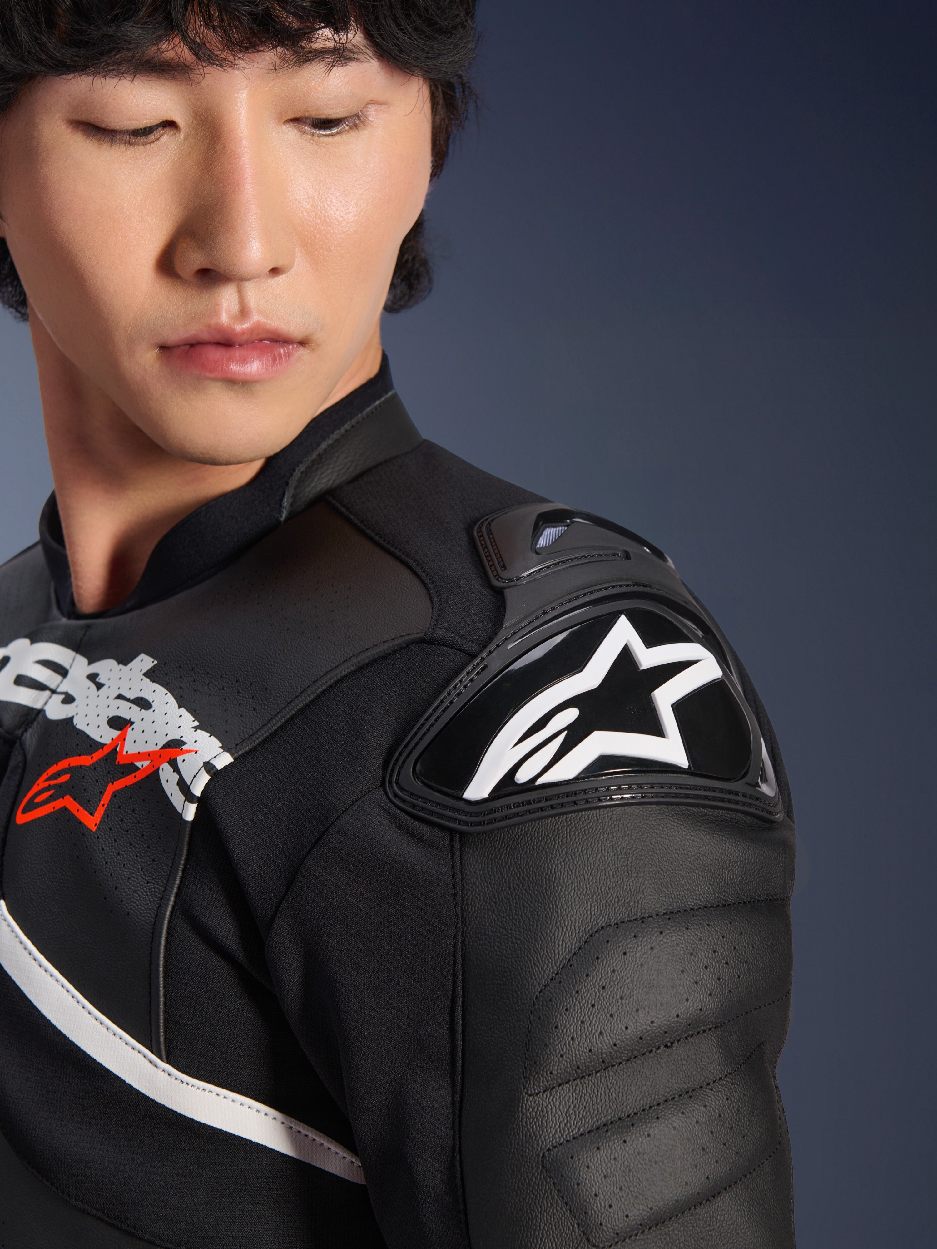 Alpinestars Atem V5 Leren Jas in Zwart Wit, close-up van de DFS RR-schouderprotector met wit sterlogo, geperforeerde lederen constructie, op racen geïnspireerde graphics op de borst