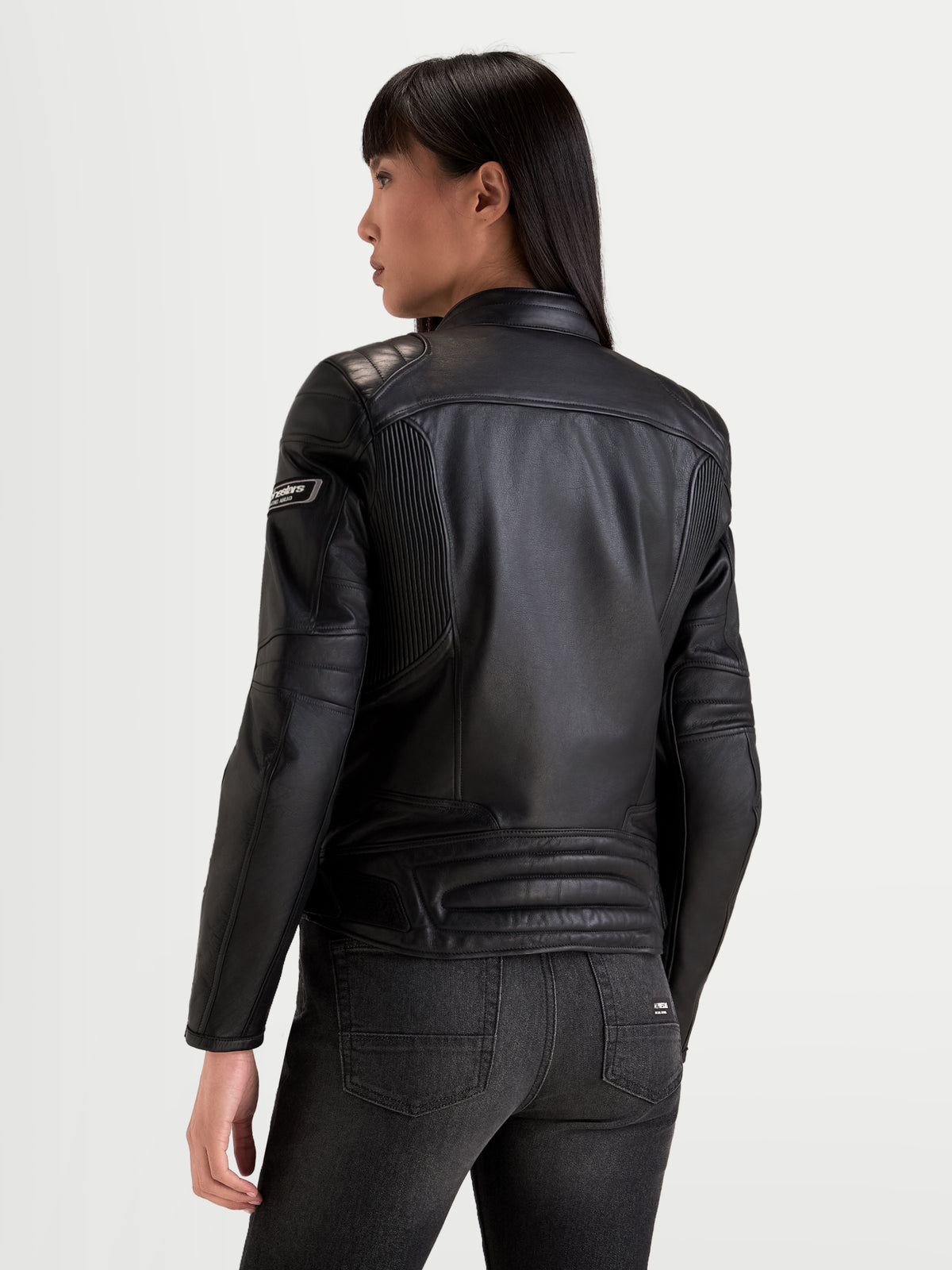 Alpinestars Revea Femme Veste en cuir, blouson de moto urbain pour femme, noir, vue de dos montrant la construction en cuir de bovin pleine fleur et le rembourrage des épaules porté par un modèle