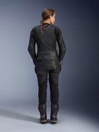 Alpinestars Stella GP Plus V4 leren damesjas, volledig zwart, volledig achteraanzicht van een vrouwelijke motorrijder met bijpassende leren broek en laarzen, strak minimalistisch ontwerp met een klein rood logo op de nek, sportief getailleerd silhouet voor dames