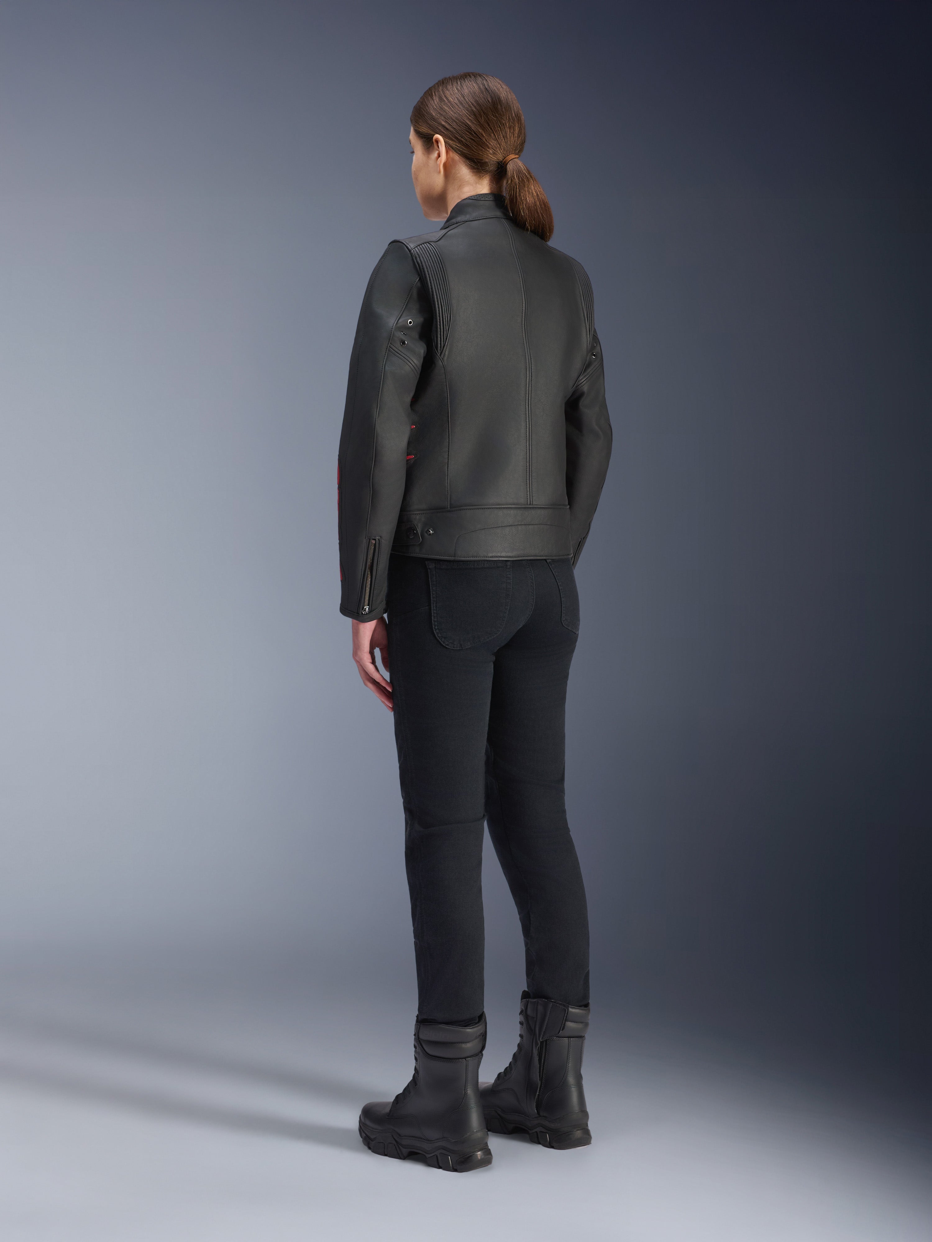 Alpinestars Stella Dyno Leren Jas, dames motorjas, zwart Haute Rood, achteraanzicht, gedragen met zwarte motorbroek en zwarte laarzen, premium lederen afwerking met erfgoedstijl