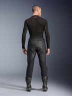 Alpinestars Missile V3 Leren Broek, zwart, achteraanzicht op model die een zwart compressieshirt met lange mouwen en racelaarzen draagt, premium leren constructie met hoge taille overlap en stretchzones, professionele motorrace-uitrusting