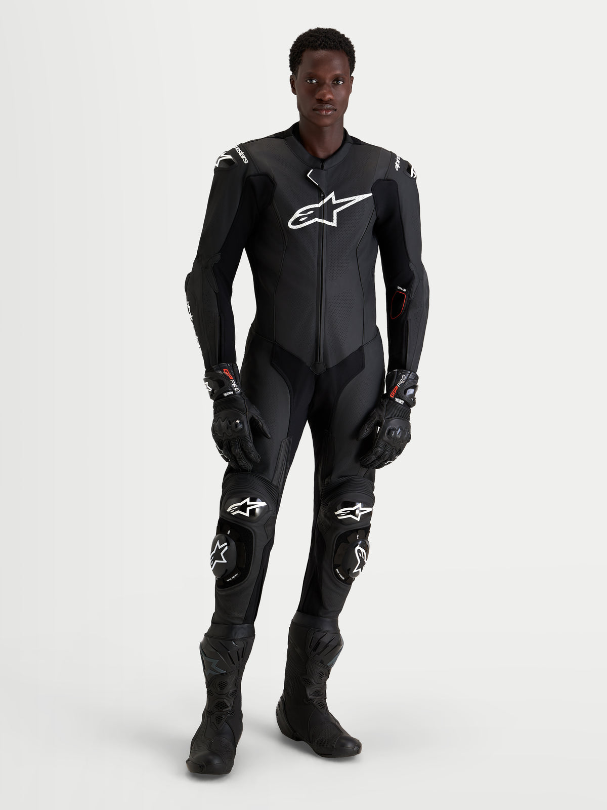 Alpinestars Missile V3 Leather Suit 1 Pc, combinaison moto en cuir pour homme, noire avec des logos blancs, portée par un modèle