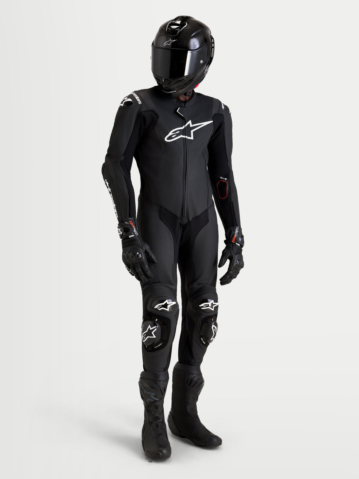 Combinaison en cuir Missile V 3 1 Pc d'Alpinestars, combinaison moto noire pour homme certifiée AAA, portée par un pilote avec casque, bottes et gants noirs