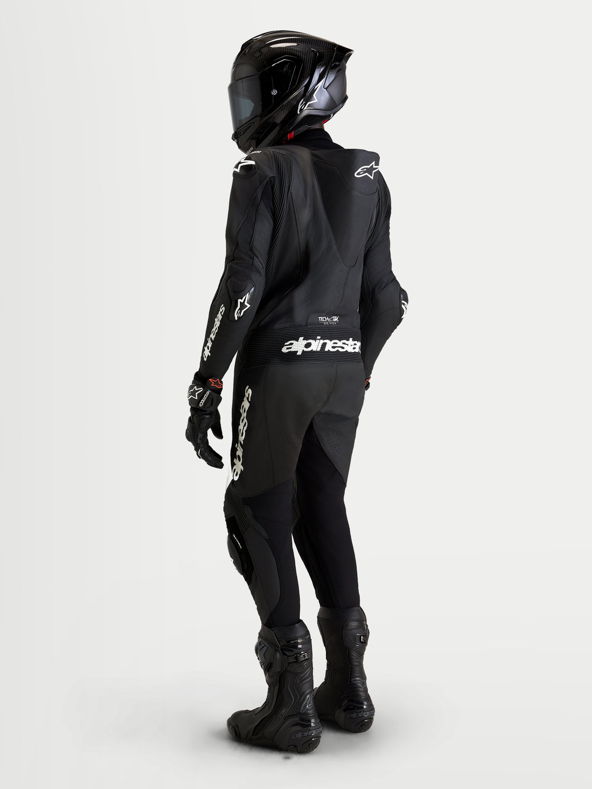 Combinaison en cuir Missile V3 1 Pc d'Alpinestars, combinaison moto pour homme en noir, vue de dos montrant la bosse aérodynamique et les détails de marquage