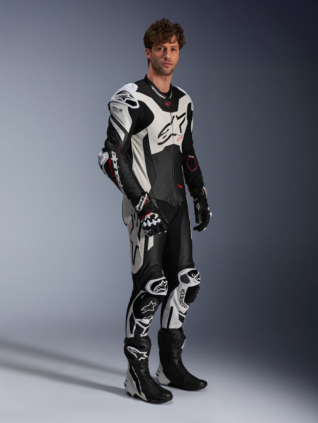 Alpinestars GP Plus V4 Sprint, combinaison en cuir 1 pièce pour homme, noire, blanche et rouge fluo, Tech-Air Ready, portée par un mannequin avec bosse aérodynamique.