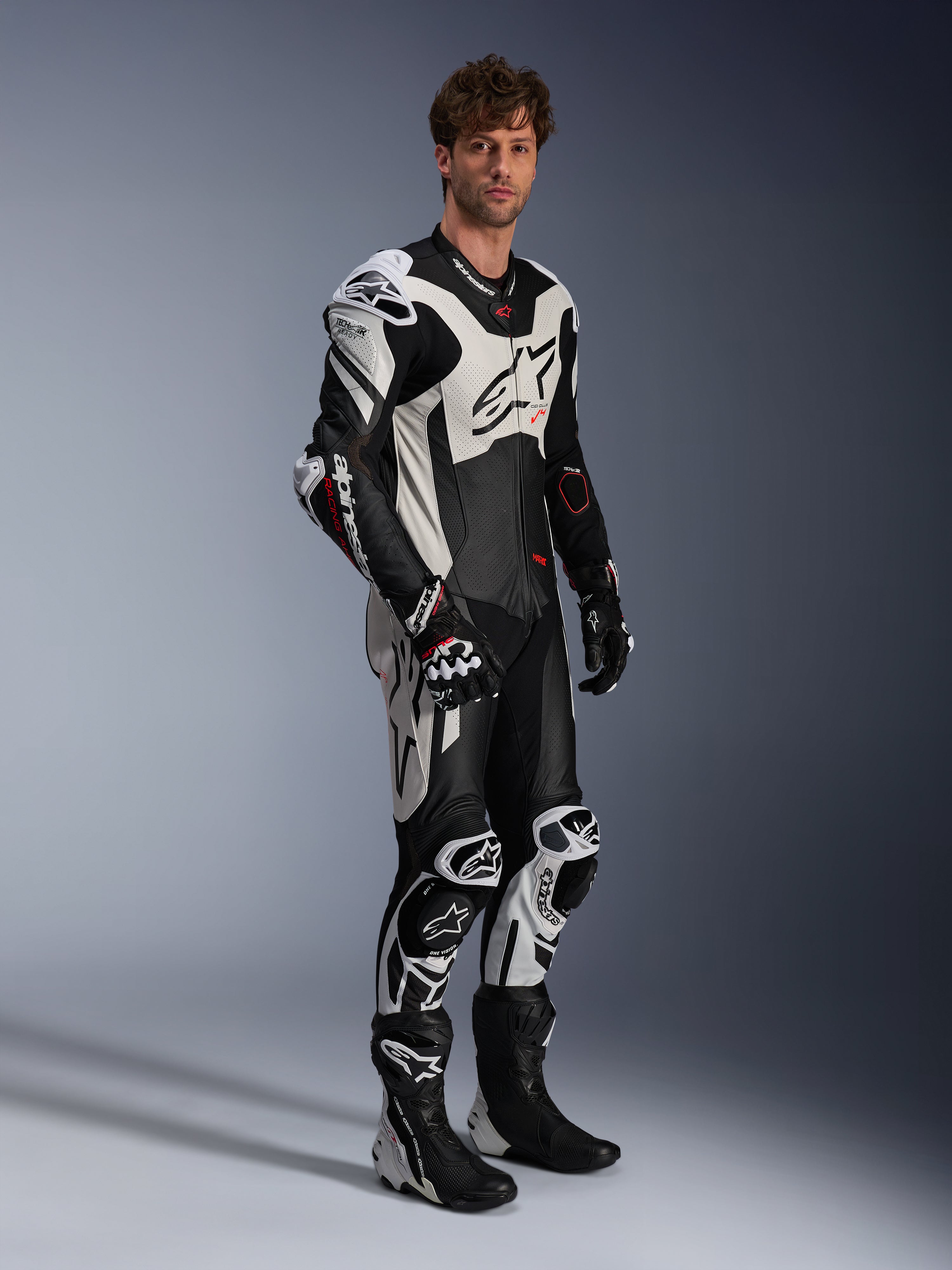 Alpinestars GP Plus V4 Sprint, combinaison en cuir 1 pièce pour homme, noire, blanche et rouge fluo, Tech-Air Ready, portée par un mannequin avec bosse aérodynamique.