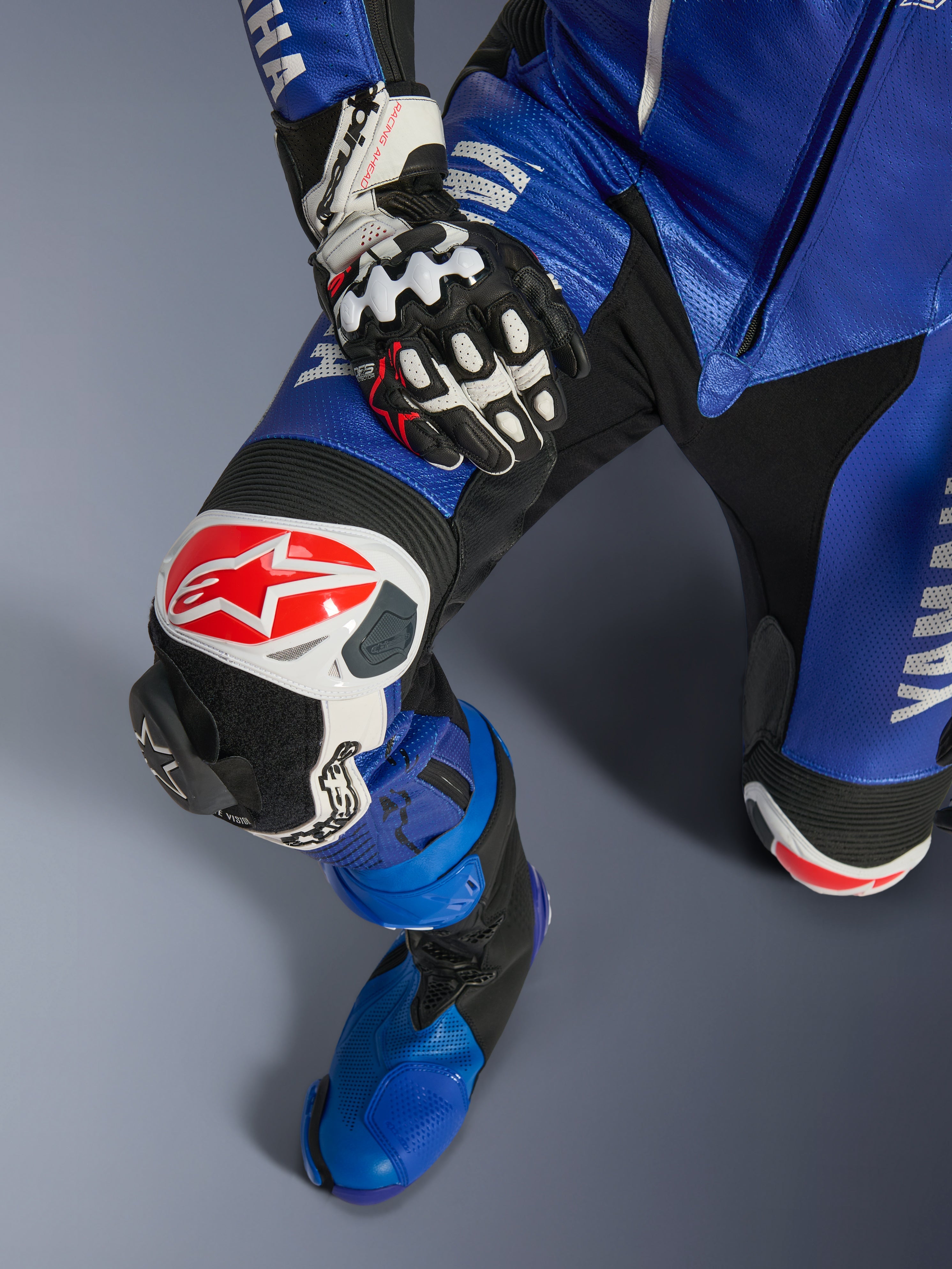 Alpinestars Yamaha GP-R7 Einteiliger Lederanzug, Motorradanzug, Metallic-Blau und Schwarz, mit weißem und rotem Alpinestars-Logo auf dem Knieschutz, austauschbarem GP-Knieschleifer und passendem blauem Rennstiefel, professionelle rennstreckentaugliche Ausrüstung