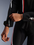 Combinaison en cuir Alpinestars GP Force V2, combinaison de moto 1 pièce, noir, blanc et rouge fluo, vue rapprochée du poignet zippé et du réglage de l'avant-bras, cuir de bovin de haute qualité avec détails perforés et marquage 'one vision' sur la fermeture éclair.
