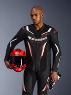 Alpinestars GP Force V2 Leather Suit, combinaison de moto 1 pièce, noir, blanc et rouge fluo, portée par un mannequin tenant un casque et des gants rouges, design racing épuré avec cuir perforé et logos distinctifs