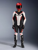 Combinaison en cuir Alpinestars GP Force V2 - 1 pièce, blanc, noir et rouge fluo, équipement de course complet avec casque rouge, gants et bottes noirs, design aérodynamique et logo Alpinestars sur la poitrine et les genoux