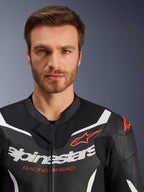 Alpinestars GP Force V2 2-teilige Lederkombi-Jacke, Schwarz Weiß Rot Fluo, Nahaufnahme-Porträt mit perforiertem Leder, weißem Alpinestars-Branding und rotem 'RACING AHEAD' Schriftzug, Performance-Motorradausrüstung