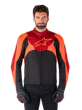 Alpinestars T-Jaws V4 Wasserdichte Jacke, Sport-Textil-Motorradjacke, Schwarz mit Red Fluo und dunkelroten Akzenten, getragen von einem männlichen Model mit passenden Handschuhen, technische Fahrerausrüstung mit markantem Stern-Logo auf der Brust.