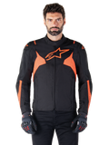 Alpinestars T-Jaws V4 Waterproof Jacke, Motorrad-Sportjacke, Schwarz und Red Fluo, mit Neon-Akzenten und einem markanten Stern-Logo auf der Brust, getragen von einem männlichen Model mit schwarzen Motorradhandschuhen, schlankes, vom Rennsport inspiriertes Textildesign