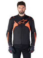 Alpinestars T-Jaws V4 Waterproof Jacke, Motorrad-Sportjacke, Schwarz und Red Fluo, mit Neon-Akzenten und einem markanten Stern-Logo auf der Brust, getragen von einem männlichen Model mit schwarzen Motorradhandschuhen, schlankes, vom Rennsport inspiriertes Textildesign